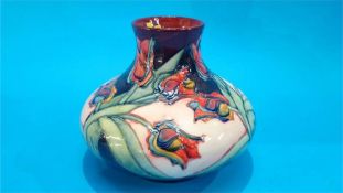 A modern Moorcroft squat shaped vase, decorated with stylised tulips on a pale pink and blue ground.