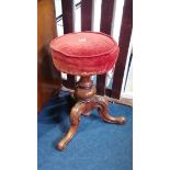 A Victorian walnut circular piano stool.