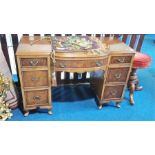 A walnut bow fronted desk with seven drawers. 111cm wide