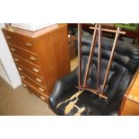Black swivel chair and a teak chest of drawers