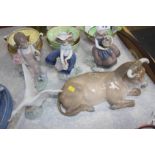 A Lladro cow and four figures