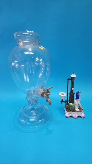 A large glass water urn and a candlestick
