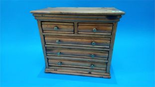 A miniature pine chest with two short and three long drawers. 33.5cm wide