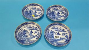Four blue and white shallow willow pattern dishes