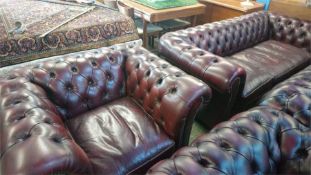 An Oxblood Chesterfield tub chair and a three seater settee
