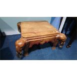 A hardwood occasional table with carved elephants