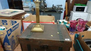 A canvas trunk and a brass candlestick