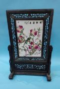 An Oriental porcelain table screen, in carved hardwood frame