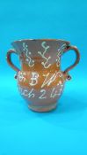 A Victorian glazed terracotta slipware two handled jug, decorative inscription 'T and BW March 24