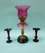 Oil lamp with cranberry glass reservoir and shade and a pair of vases
