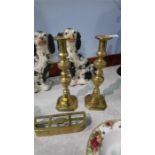 A pair of brass candlesticks and a small fender