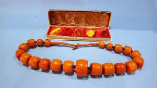 A large amber coloured necklace and a collection of amber coloured pieces