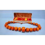 A large amber coloured necklace and a collection of amber coloured pieces