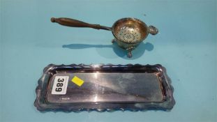 A silver tea strainer and a Continental silver tray