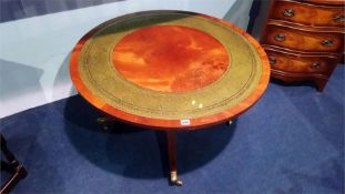 A reproduction mahogany circular coffee table, with inset leather top. 90.5cm diameter