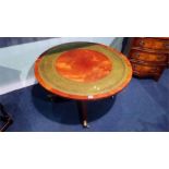 A reproduction mahogany circular coffee table, with inset leather top. 90.5cm diameter