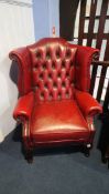 A red leather high back Chesterfield armchair