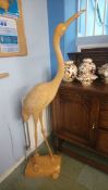 A tall carved wood figure of a Crane