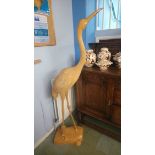 A tall carved wood figure of a Crane