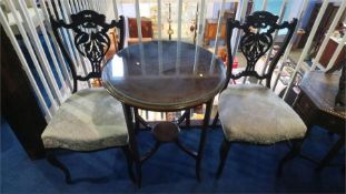 An Edwardian circular table and a pair of Edwardian chairs
