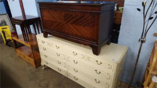 A cream chest of drawers and a blanket box