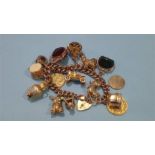 A gold charm bracelet, various charms including one full and one 1/2 sovereign. Total weight 99.9