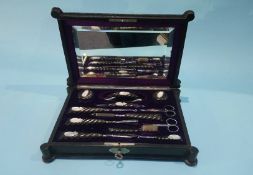 An ebony and mother of pearl mounted travelling vanity set, in fitted Moroccan leather case