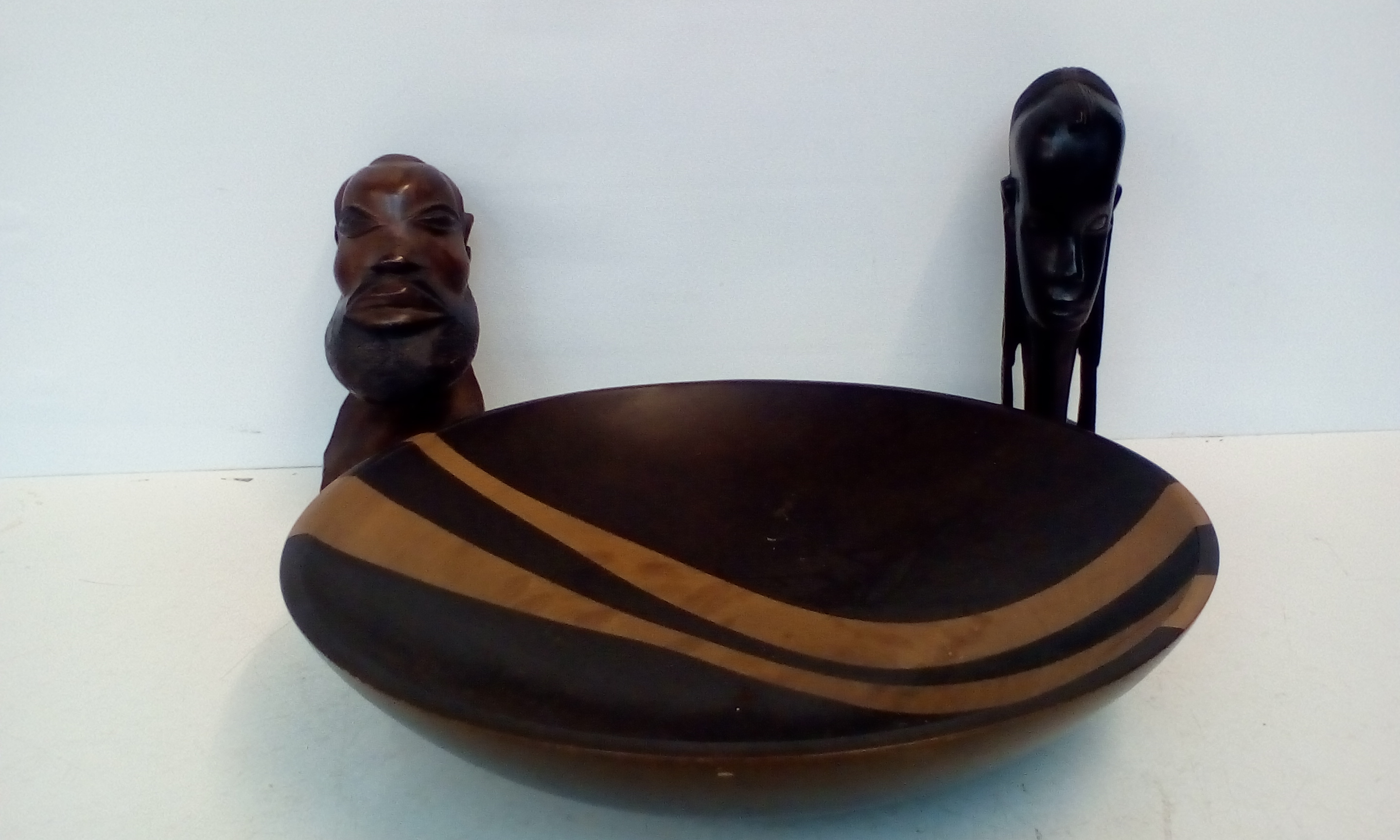 Two ethnic busts together with a treen bowl