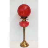 Large brass bass oil lamp with cranberry glass sha