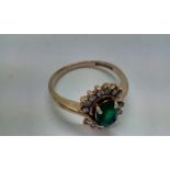 9 carat gold silver ring with central emerald surr