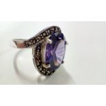 Silver dress ring set with large purple gemstone,
