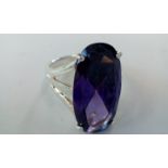 Silver dress ring set with large purple gemstone,