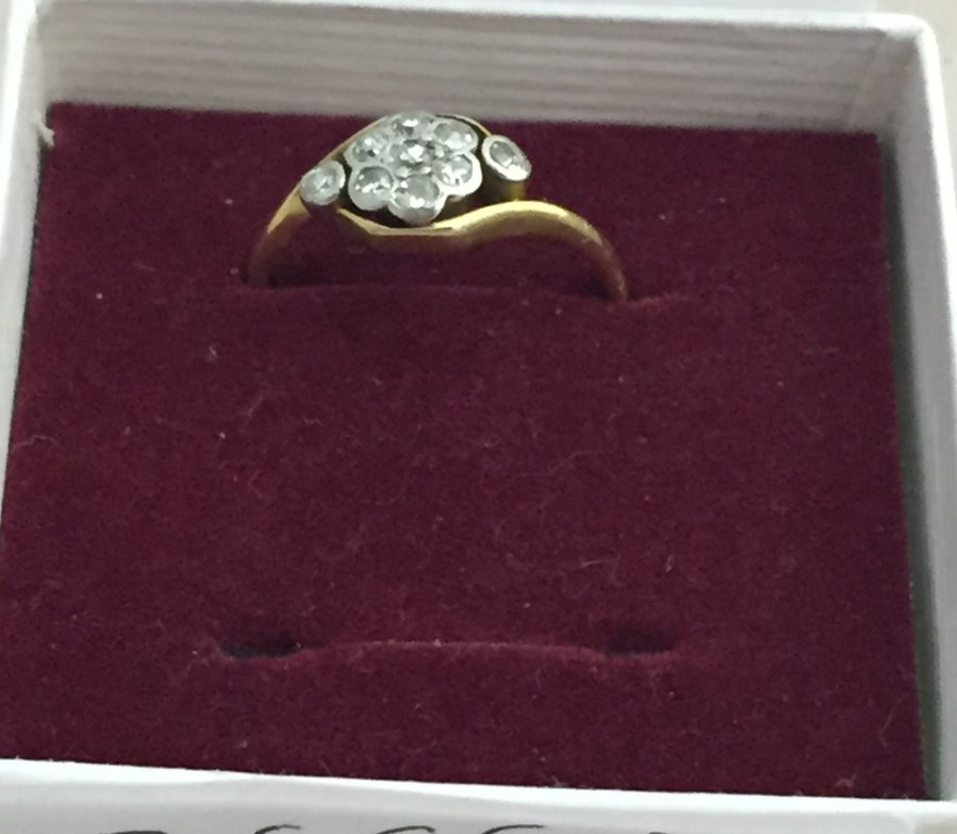 An 18ct diamond daisy ring with diamond set shoulders