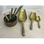 A quantity of copper pans and brass scoops