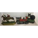 Three painted cast-iron door stops: train,