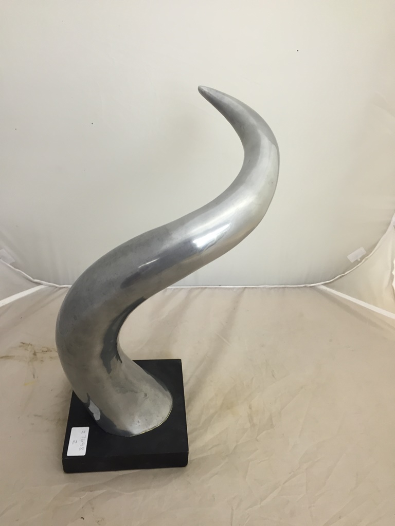 A polished aluminium sculpture of a horn
