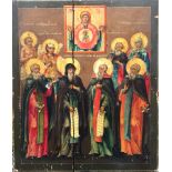 A Russian Icon: Painted on panel, depicting eight Saints surmounted by the Virgin & Child & script,