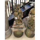 A stone garden ornament of a girl leaning against a ewer on a round plinth surmounted by a