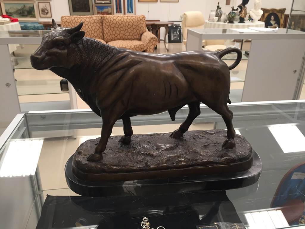 A bronze figure of a bull on a marble base