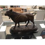 A bronze figure of a bull on a marble base