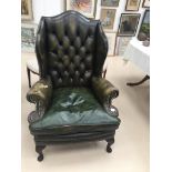 A leather wingback buttonback chair (damage to upholstery)