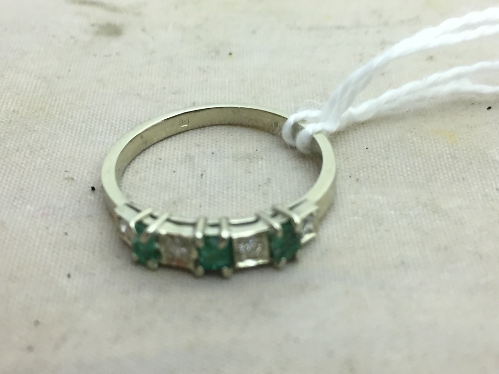 An 18ct diamond and emerald half eternity ring