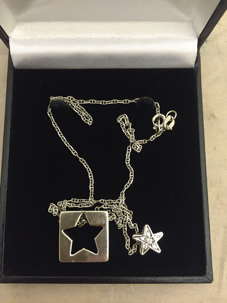 A diamond set star pendant on an 18ct chain