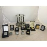 A quantity of cased Zippo lighters and pouch; together with chrome pipe rack,
