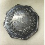 A silver Banque De France octagonal token