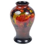 A Moorcroft Vase: "Leaf & Berry pattern" on an orange & blue ground, of baluster form,