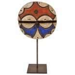 A Congo/Gabon Teke Mask: Round shaped mask in red, white and blue decoration on metal stand.