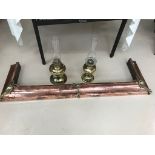 Two brass oil lamps with storm shades; together with a stylish copper and brass fender,