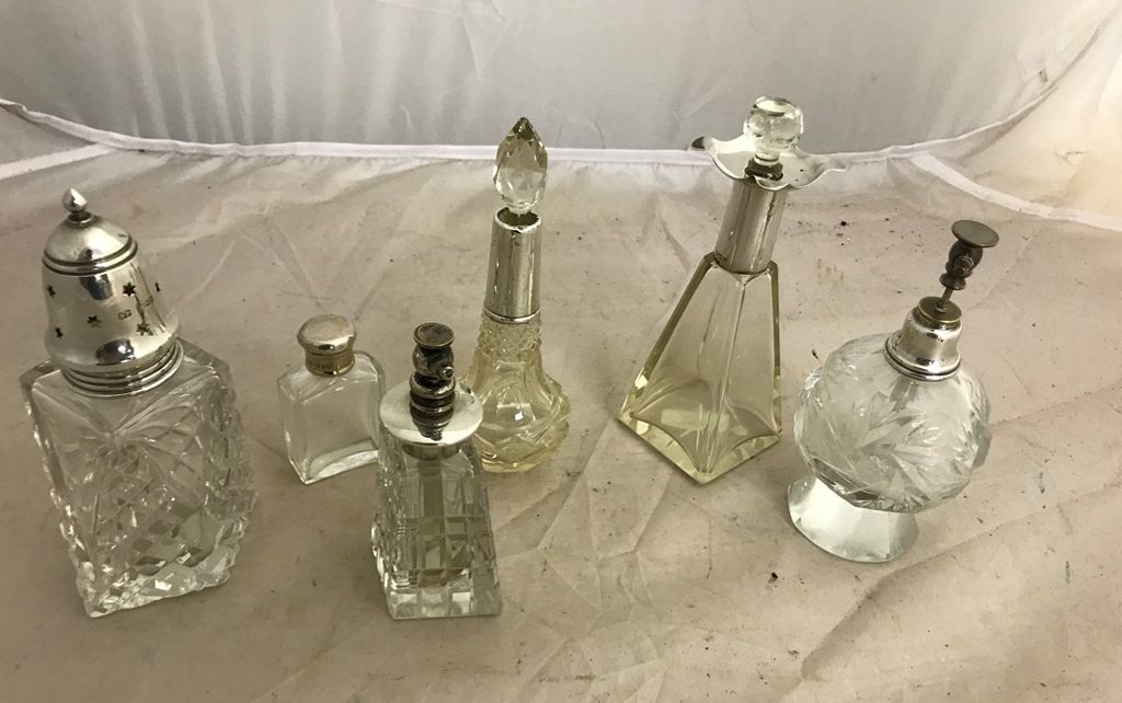 Six silver-topped glass items: perfume atomisers,