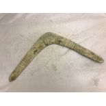 An early 20th century boomerang carved with indigenous animals and Ayer`s Rock